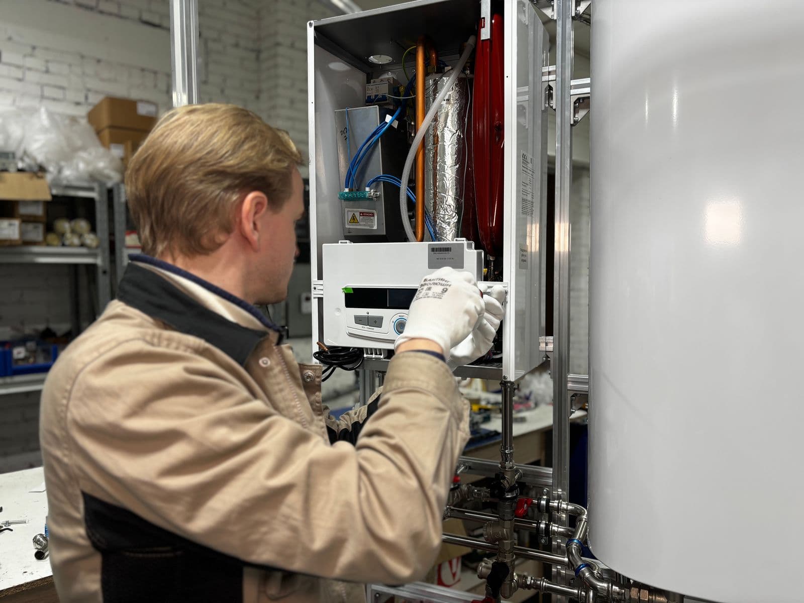 A technician servicing a water heater tank